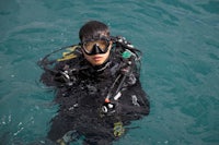 a scuba diver wearing a mask and goggles in the water