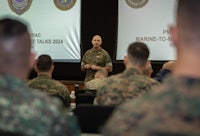 a military man is giving a presentation to a group of people