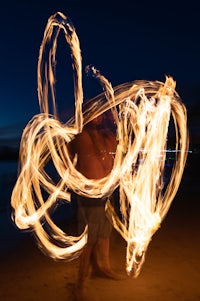 a man is doing a fire dance on the beach