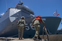 two men standing next to a ship