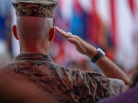 a military man saluting in front of flags