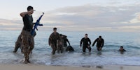 a group of marines walking in the ocean